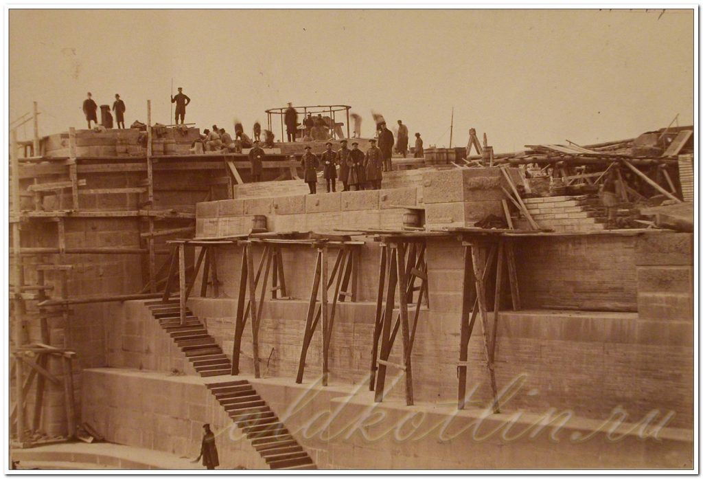 Рабочие и инженеры на внутренних стенках дока, к которым примыкает лестница.